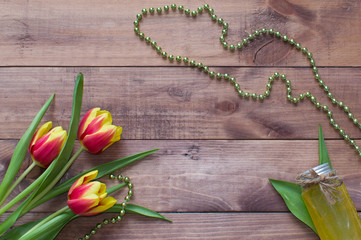 Flatlay Spring Easter bouquet of tulip flowers with cosmetic product on wooden background.View with copy space