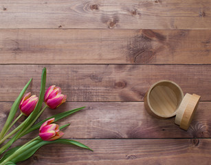 Flatlay Spring Easter bouquet of tulip flowers with wood empty box on wooden background.View with copy space