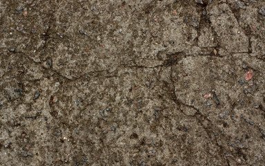 The texture of the old concrete wall with stones, cracks, dust, cracks, roughness. Texture, background