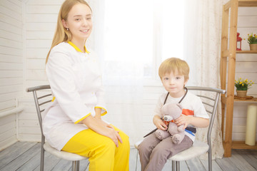 Pediatrician examining baby boy. Doctor using stethoscope to listen to kid and checking heart beat