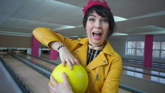 girl pulls her fingers out of a bowling ball