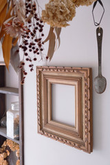 Empty picture frame hanging on the wall, view from the side with other decorative props