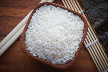Raw uncooked sushi rice in wooden bowl. Concept for preparing sushi