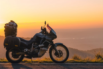 Fototapeta na wymiar Adventure motorcycle, silhouette touristic motorbike. the mountain peaks in the dark colors of the sunset. Copy space. Concept of Tourism, adventures, active lifestyle, Transfagarasan, Romania