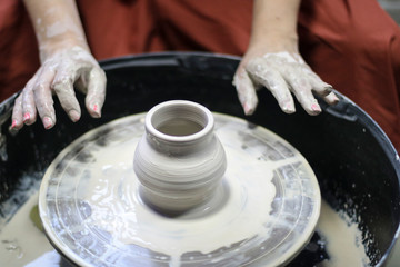 Hands of a Potter creating the clay.  Vessel on the Potter's wheel.