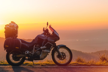 Adventure motorcycle, silhouette touristic motorbike. the mountain peaks in the dark colors of the sunset. Copy space. Concept of Tourism, adventures, active lifestyle, Transfagarasan, Romania