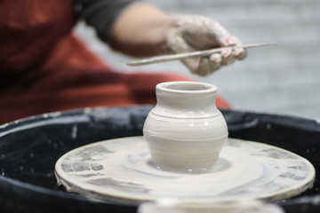 Hands of a Potter creating the clay.  Vessel on the Potter's wheel.