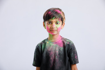Indian little boy playing with the color and giving multiple expressions in holi festival 