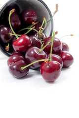 White cup with red sweet cherry isolated on a white background..