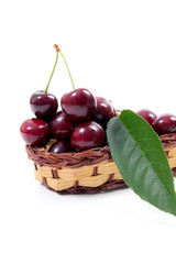 Yellow wooden basket with red sweet cherry isolated on a white background..