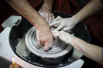 Hands of a Potter creating the clay on the Potter's wheel.