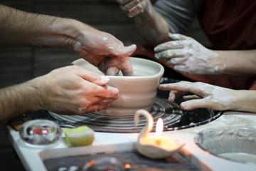 Hands of a Potter creating the clay.  Vessel on the Potter's wheel.