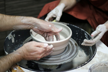 Hands of a Potter creating the clay.  Vessel on the Potter's wheel.