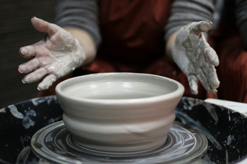 Hands of a Potter creating the clay.  Vessel on the Potter's wheel.