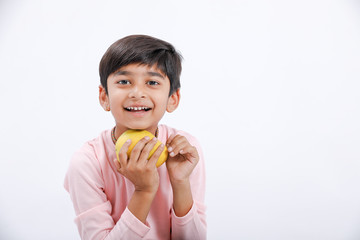 Cute indian/Asian little boy eating Mango with multiple expressions. isolated over white background