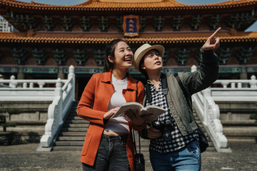 group of girls tourists visit confucius Temple in taipei Taiwan. young woman travelers love history. holidays travel concept beautiful ladies best friends looking for direction in shrine in china.