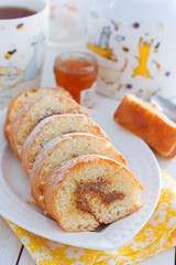 Biscuit roll with boiled condensed milk on a white plate, selective focus