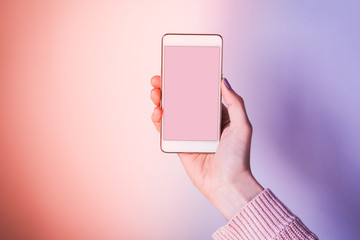 Fototapeta na wymiar Hand with mobile phone screen on pink and purple