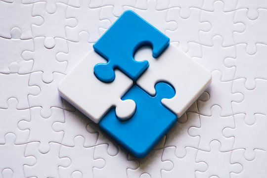 Close up blue and white plastic jigsaw. Conceptual upper and lower pieces