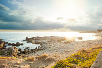 Fototapeta na wymiar Sea beach with stownes and summer sky