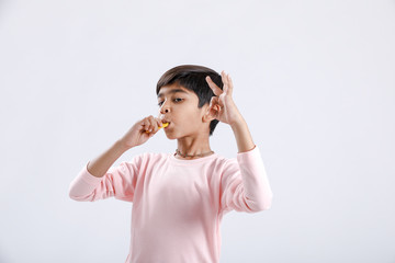 Cute indian/Asian little boy eating Mango with multiple expressions. isolated over white background