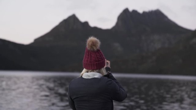 Woman photographing cradle mountain lake