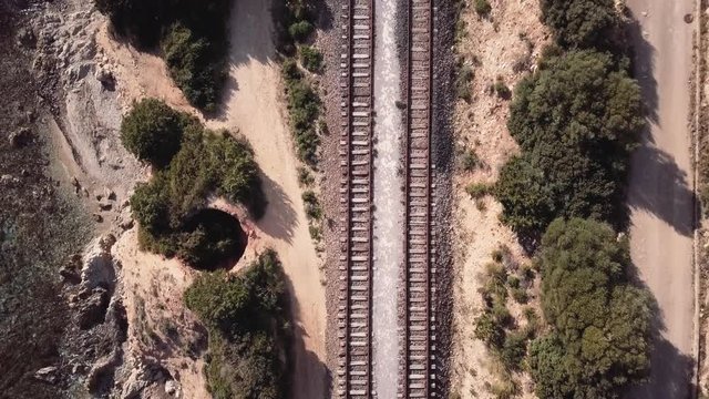 Aerial of the end of the tracks and trail. Rocks and clear water on the side. Birdeye. fullHD