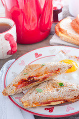 Breakfast with scrambled eggs and an open sandwich with cheese and sausage, selective focus