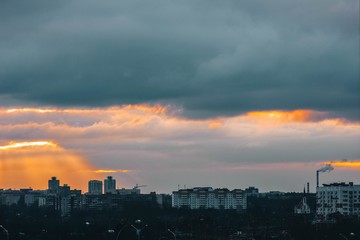 dawn sunset in a European city, the rays of the sun among the houses.