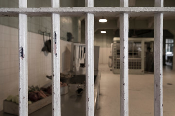 Prison bars with prison kitchen blurry background