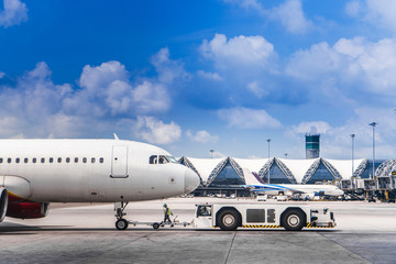 Plane being pushed back at the airport runway with blue sky, logos and trademark removed