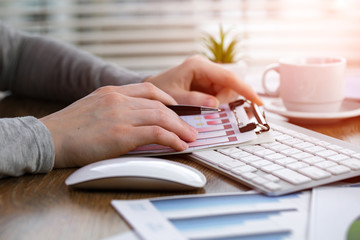 Woman's hands with items for doing business in the office