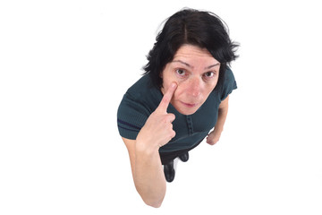 woman with finger on eye on white