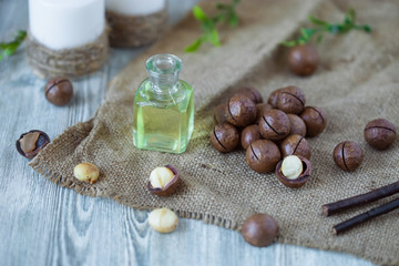 Macadam nuts, walnut oil, on wooden background. Relax, health care, body care