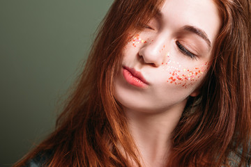 Fototapeta premium Young woman portrait. Skeptical facial expression. Redhead female with pursed pout lips looking sideways.