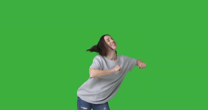 Ecstatic woman dancing over green background