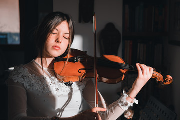 Ragazza mentre suona il violino in casa