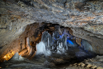 Underground glacier in Glaciers Cave in Apuseni mountains, Scarisoara, Romania. Ice and big icicles...