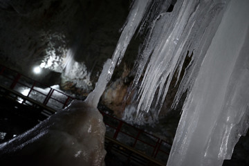 Underground glacier in Glaciers Cave in Apuseni mountains, Scarisoara, Romania. Big icicles holding on ceiling in the cave