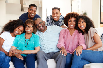 Multi generation black family sitting at home smiling to camera