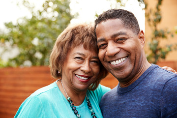 Senior black woman and her middle aged son smiling to camera, head and shoulders, close up