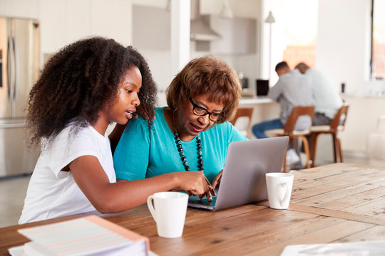 Teenage Black Girl Helping Her Grandmother Use A Laptop Computer At Home, Close Up