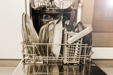 Open dishwasher machine with clean dishes and cutlery, tableware, vintage style