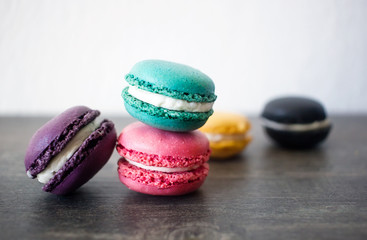 Assorted colorful french macaroons on rustic wooden table