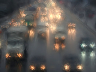 Turned on cars headlights moving in rainy twilight as impressionism stylized