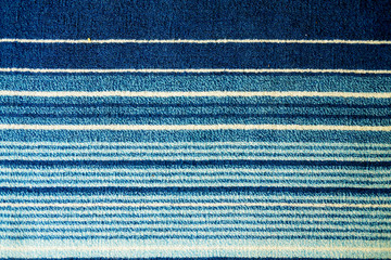 Texture of textile rug with striped pattern of white and blue