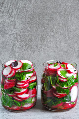 Radish salad with spinach in a jar. Fitness salad in the jar. Fresh radishes and fresh chopped spinach leaves. Vegetable salad in a jar to go.