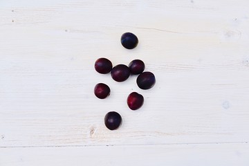 fresh plums on white wooden background