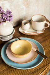 Chinese bowls , plates, utensil sets on wooden platter with chopstick and flower vase