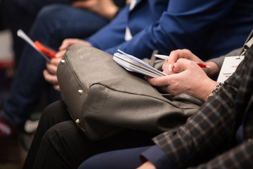 Writing in a notebook at the conference, tinted.